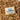 Bar of soap with a label on a bed of craft crinkle paper against a marble background