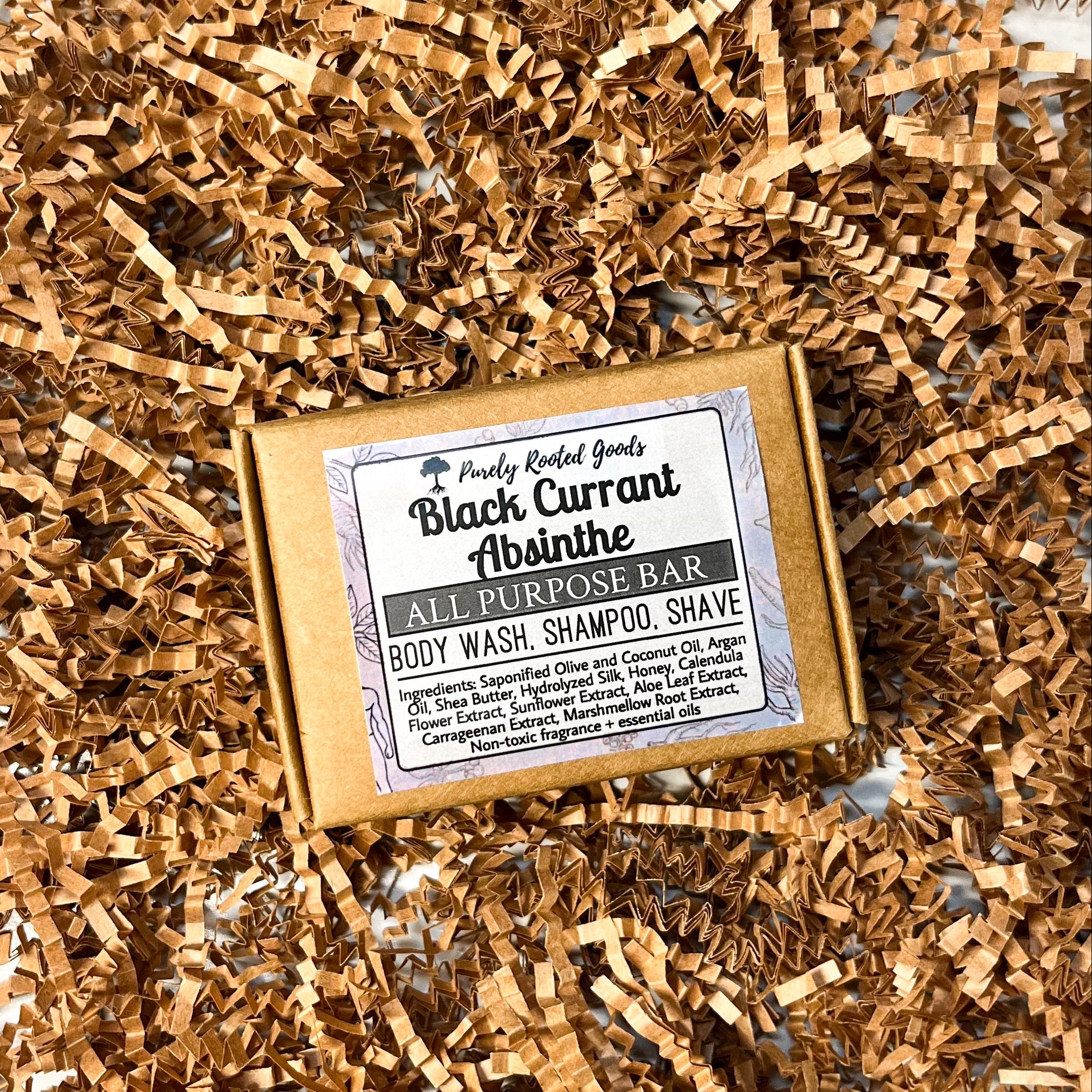 Bar of soap with a label on a bed of craft crinkle paper against a marble background